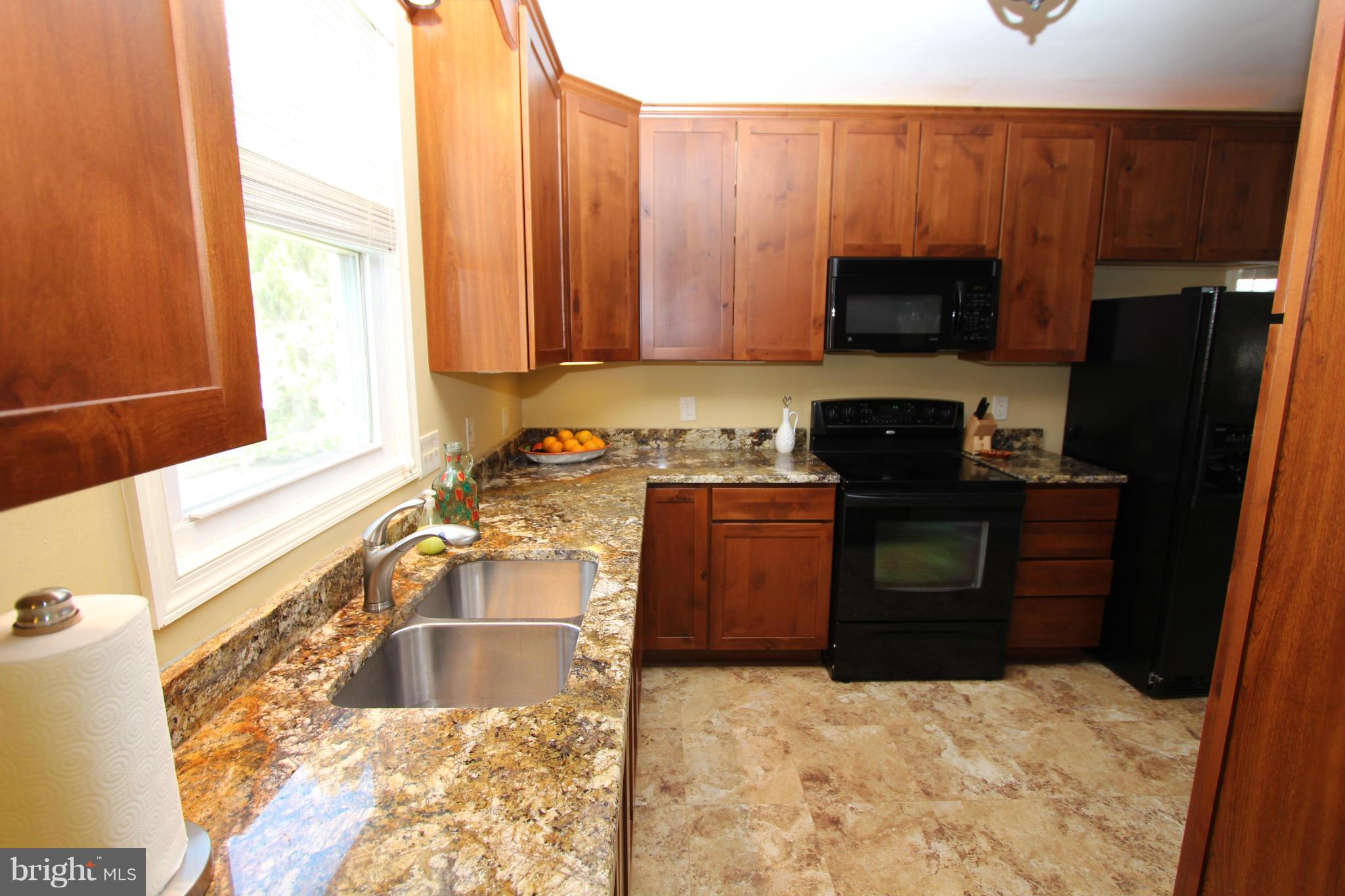8720 Windsor Mill Road Baltimore, MD 21244 - Photo 8 of 27 a kitchen with a sink stove and refrigerator