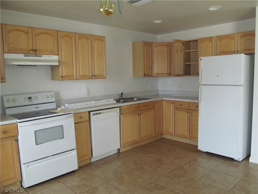 664 Alabama Road South Lehigh Acres, FL 33974 - Photo 2 of 7 a kitchen with white cabinets and white stainless steel appliances