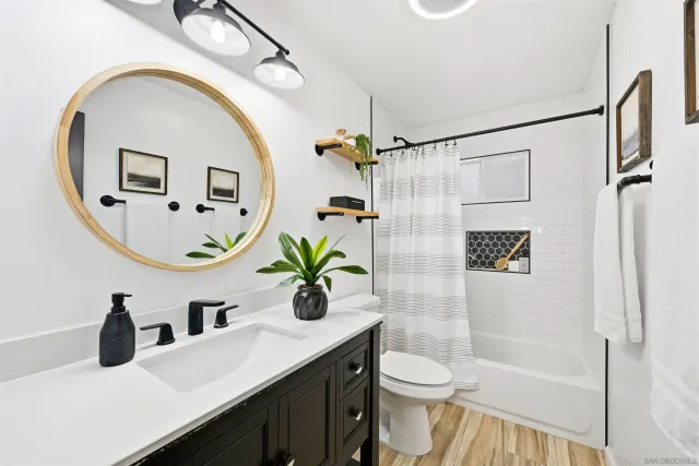 a bathroom with a sink a mirror a toilet and a shower