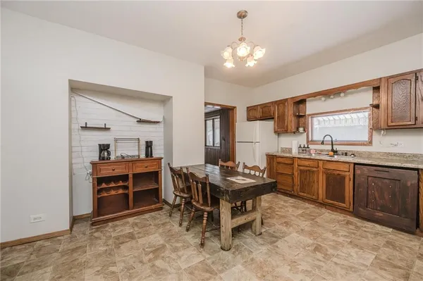 a kitchen with kitchen island granite countertop a sink appliances and cabinets