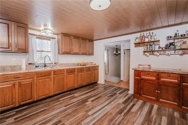 a kitchen with stainless steel appliances granite countertop a sink cabinets and wooden floor