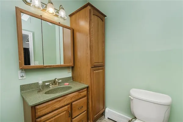 a bathroom with a granite countertop sink toilet and mirror