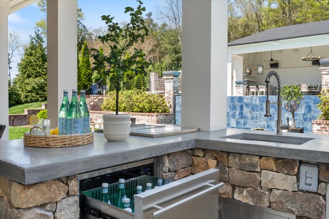 a view of a patio with table and chairs potted plants and a palm tree