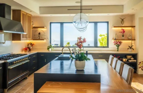 a view of a dining room with furniture a kitchen and chandelier