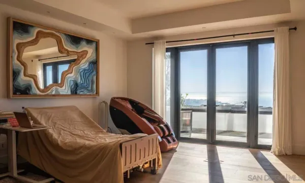 a bedroom with a bed and a large mirror next to a window