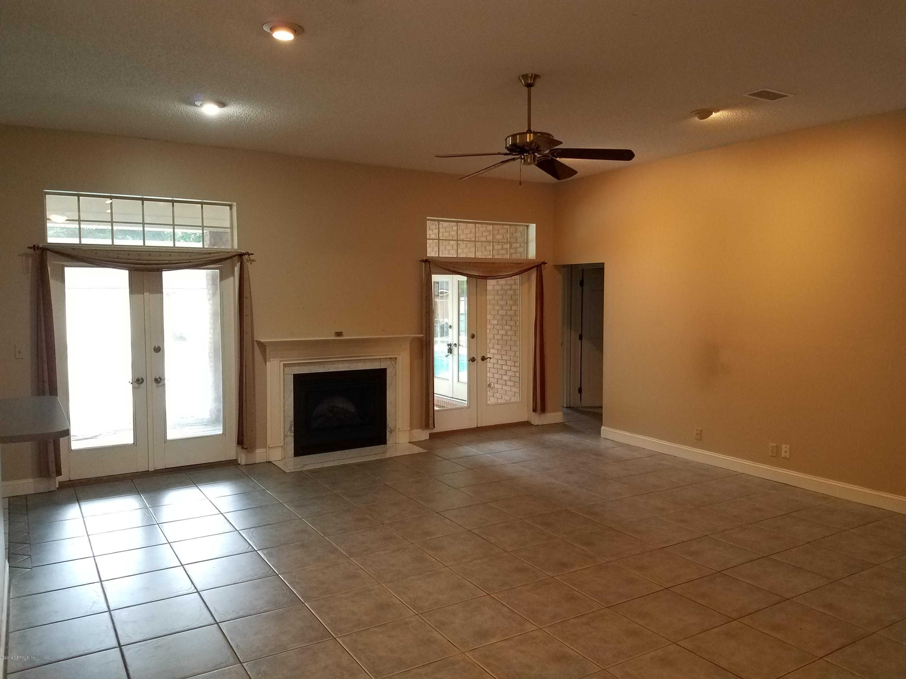 2970 Cortez Road Jacksonville, FL 32246 - Photo 5 of 12 an empty room with windows and fireplace