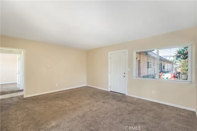 a view of a big room with windows and chandelier fan