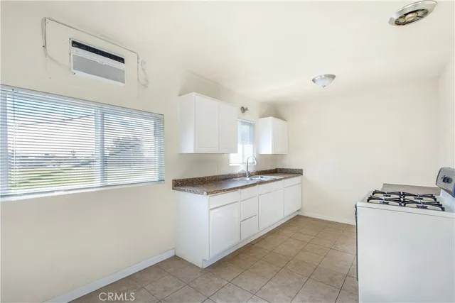 a kitchen with granite countertop a sink and a stove top oven