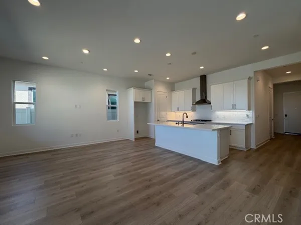 a large kitchen with stainless steel appliances kitchen island a large counter top and a wooden floors