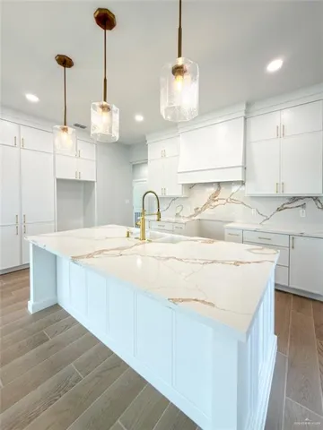 a view of a kitchen with kitchen island a sink wooden floor and windows