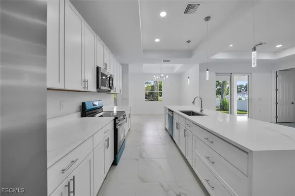 a large kitchen with stainless steel appliances lots of counter space sink and cabinets