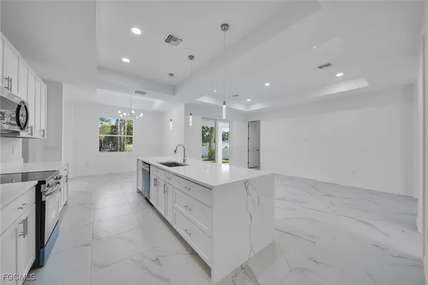 a large white kitchen with a large window