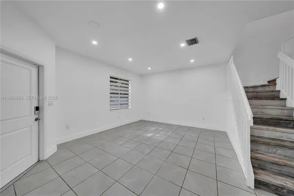 a view of an empty room and stairs