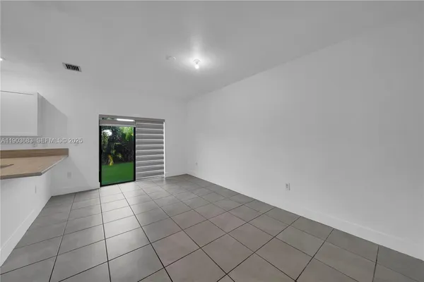 a view of an empty room with window and cabinet