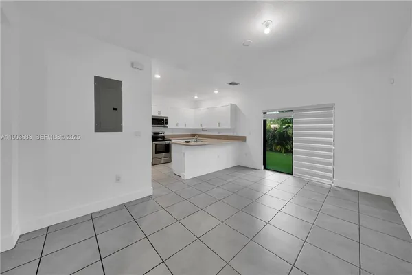 a kitchen with white cabinets a sink and appliances