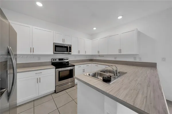 a kitchen with white cabinets and stainless steel appliances