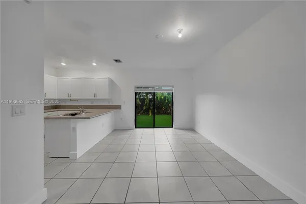 a large white kitchen with a sink and a stove top oven