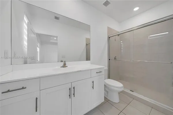 a bathroom with a double vanity sink toilet and shower