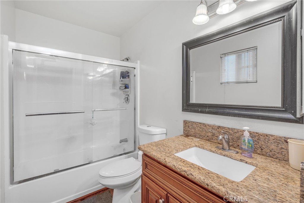 9212 Beverly Road Pico Rivera, CA 90660 - Photo 33 of 43 a bathroom with a granite countertop sink toilet a mirror and shower