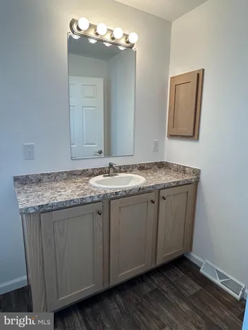 a bathroom with a granite countertop sink and a mirror