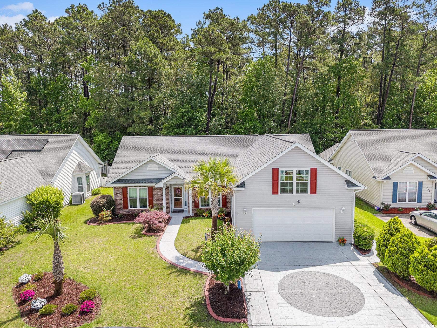 1105 Lampwick Lane Murrells Inlet, SC 29576 - Photo 5 of 40 Traditional home with concrete driveway, an attached garage, a front lawn, brick siding, and central AC unit