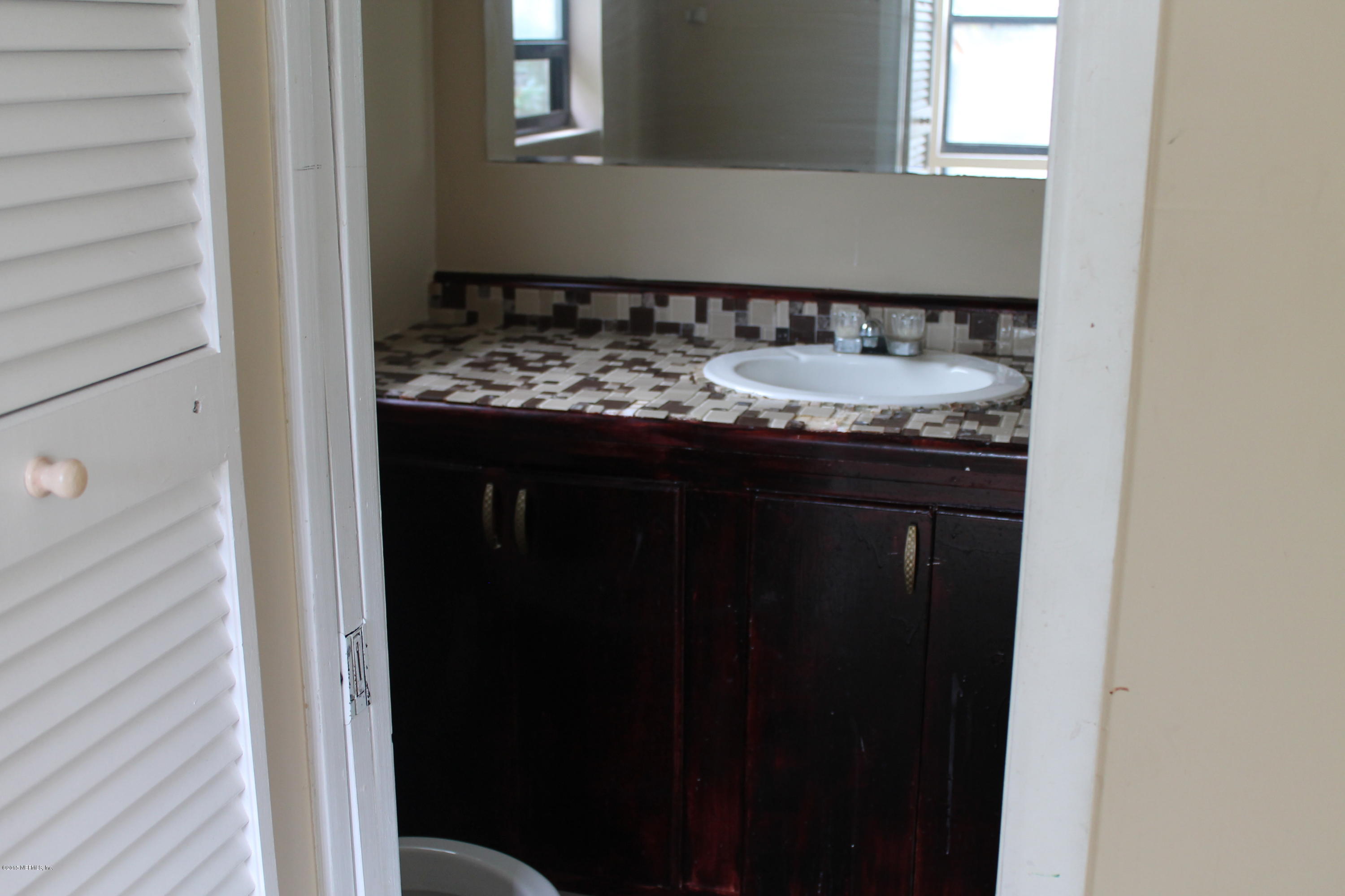 2712 Lorna Road Jacksonville, FL 32211 - Photo 25 of 30 a bathroom with a granite countertop sink and a mirror