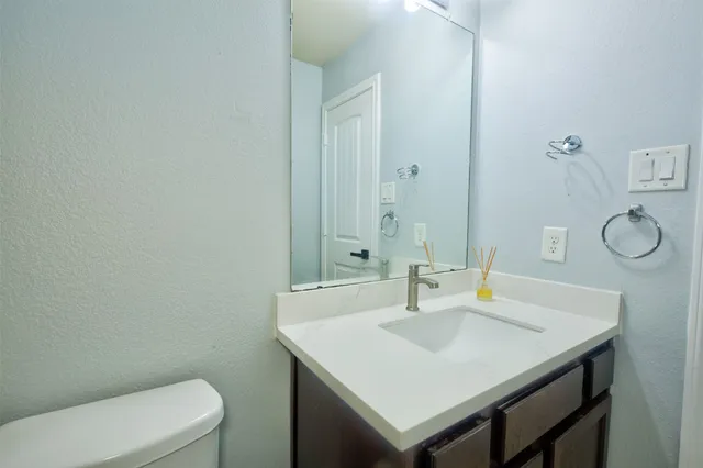 a bathroom with a sink a toilet and a mirror