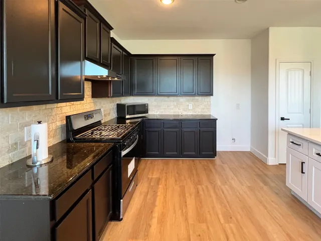 a kitchen with stainless steel appliances granite countertop a stove and a sink