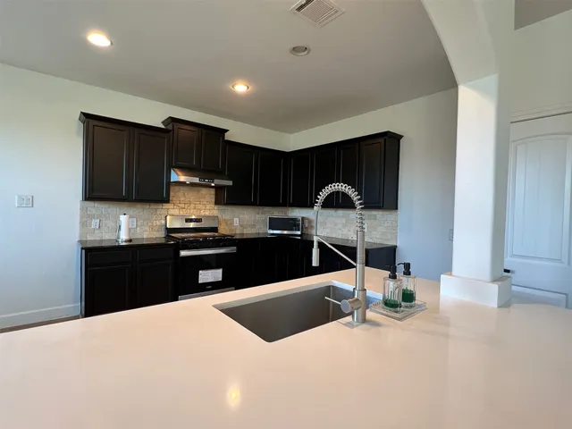 a kitchen with granite countertop a cabinets and steel appliances