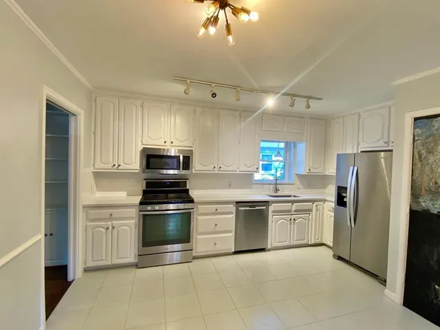 a kitchen with stainless steel appliances granite countertop a stove sink and refrigerator