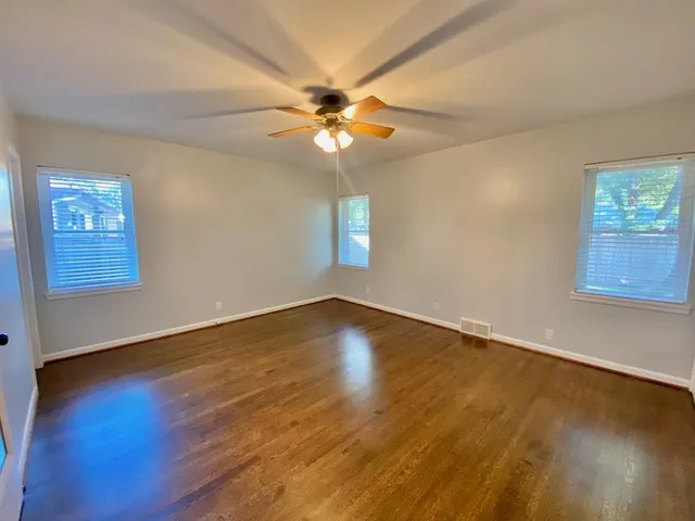 a view of empty room with wooden floor