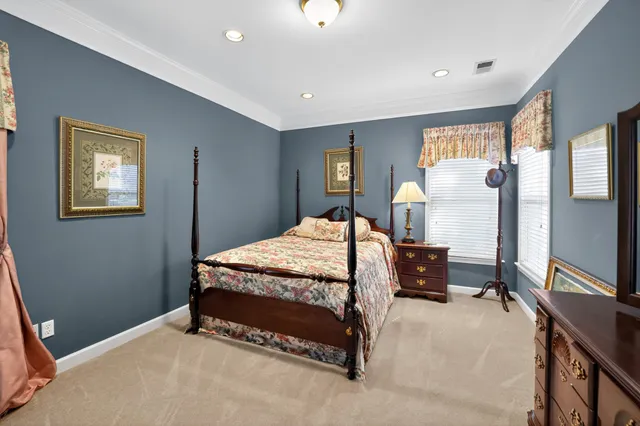a bedroom with a bed table chair and a window
