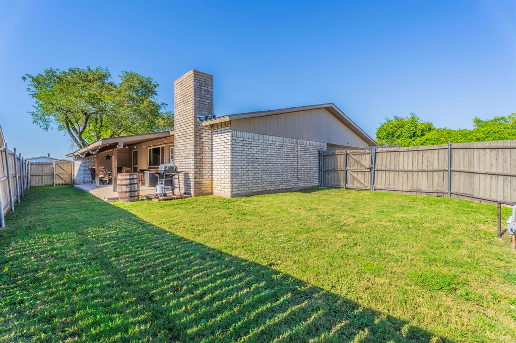 5109 Reed Drive The Colony, TX 75056 - Photo 11 of 14 a view of a house with a backyard and a patio