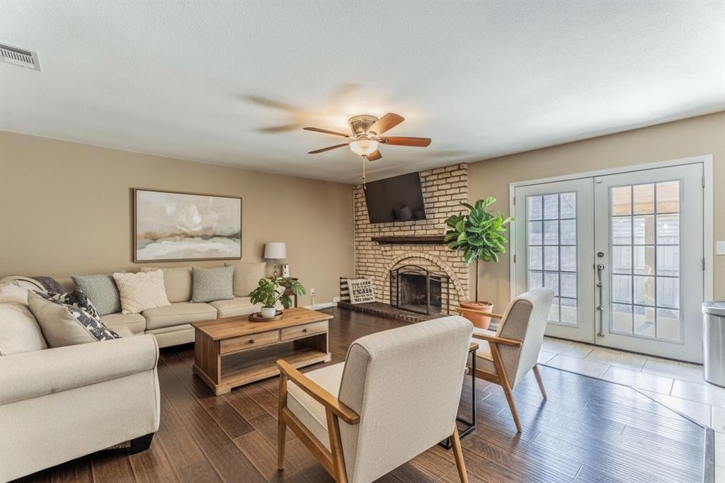 5109 Reed Drive The Colony, TX 75056 - Photo 4 of 14 a living room with furniture a fireplace and a floor to ceiling window