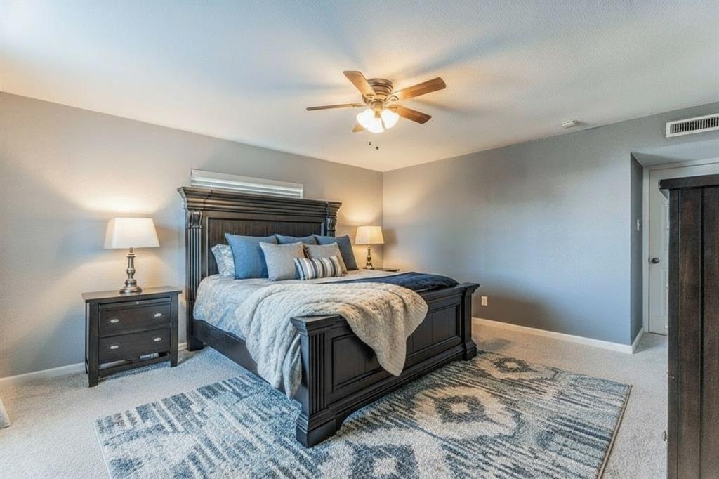 5109 Reed Drive The Colony, TX 75056 - Photo 6 of 14 a bedroom with a bed lamp and a fireplace