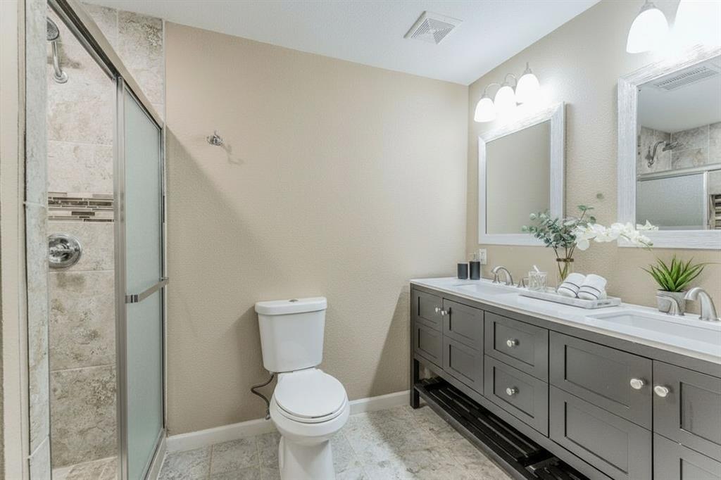 5109 Reed Drive The Colony, TX 75056 - Photo 7 of 14 a bathroom with a granite countertop toilet a sink and a mirror