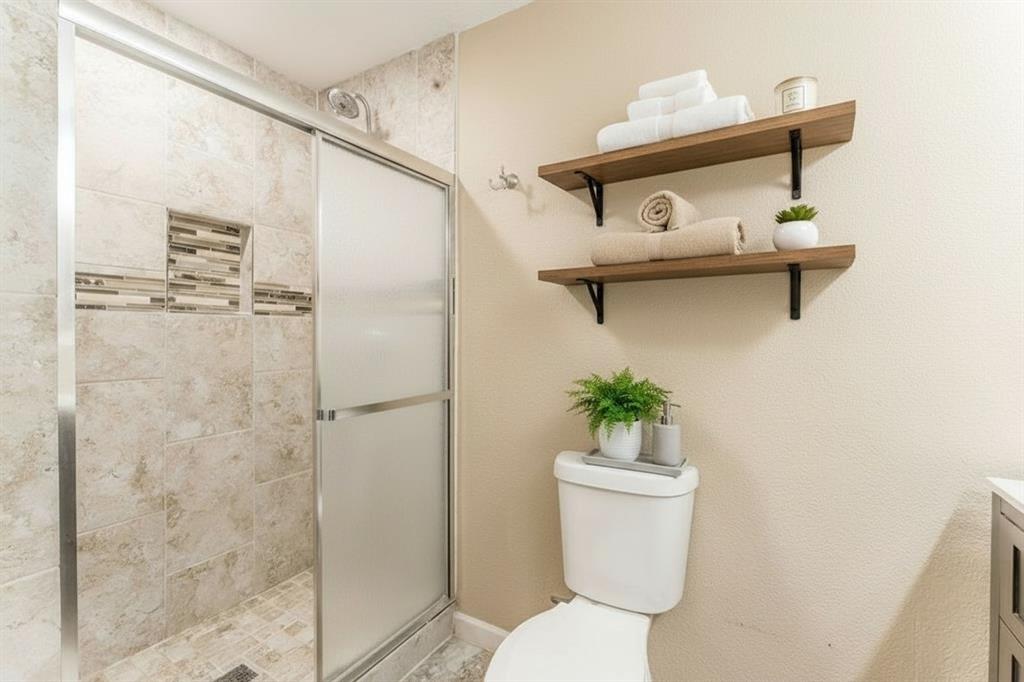 5109 Reed Drive The Colony, TX 75056 - Photo 8 of 14 a bathroom with a sink a toilet and a shower
