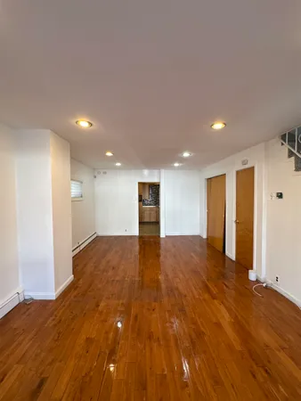 a view of empty room with wooden floor