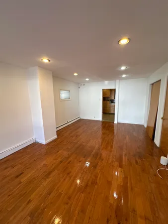 a view of a big room with wooden floor and entrance