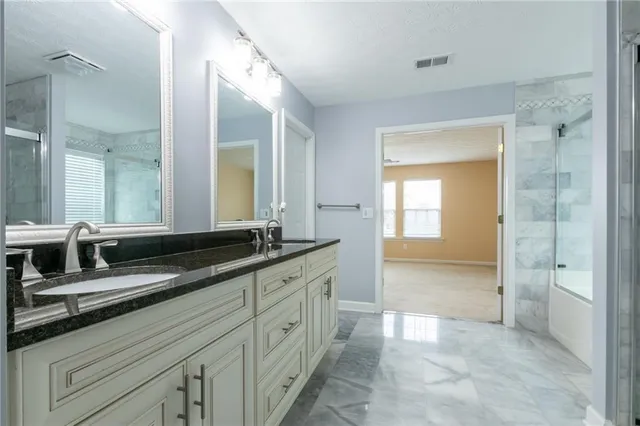 a spacious bathroom with a granite countertop sink a mirror and a