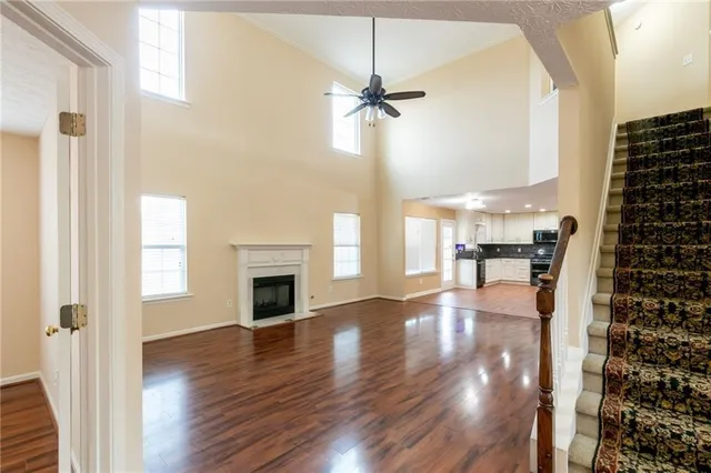 a view of a livingroom with wooden floor a fireplace and entryway