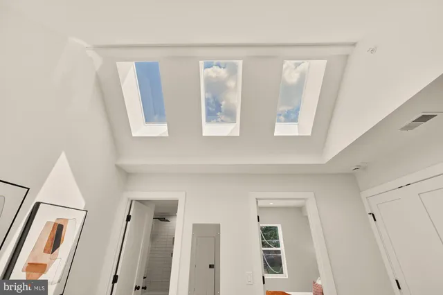 a view of two room with wooden floor and window