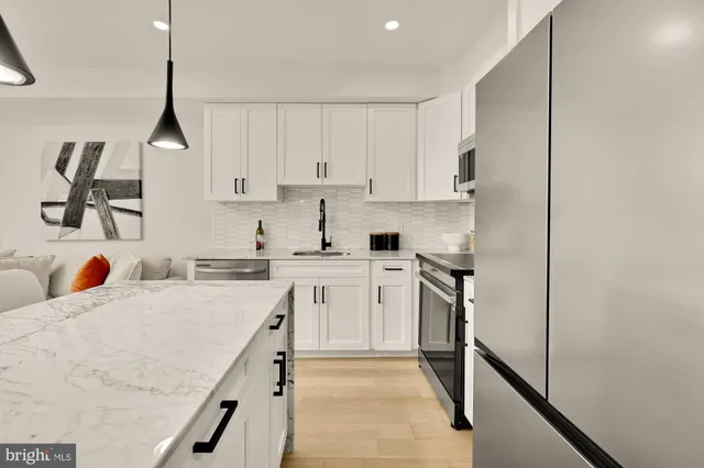 a kitchen with stainless steel appliances granite countertop a sink stove and refrigerator