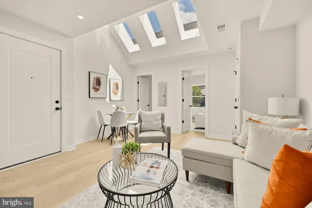 a living room with furniture a dining table and a chandelier