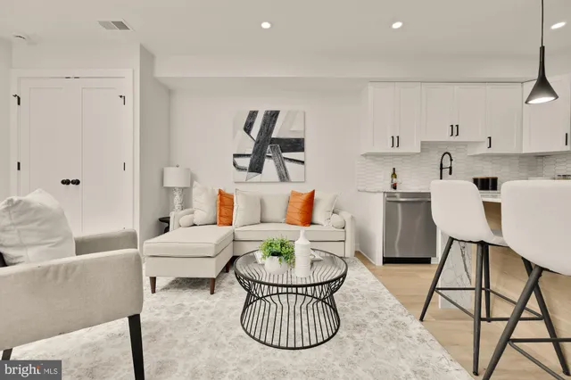a living room with furniture a rug and white walls