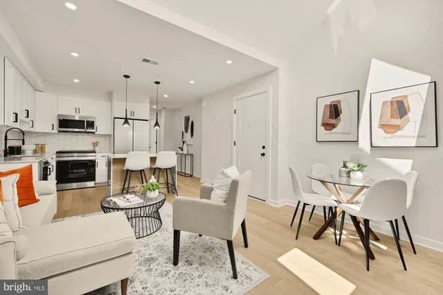 a living room with fireplace furniture and a dining table with kitchen view