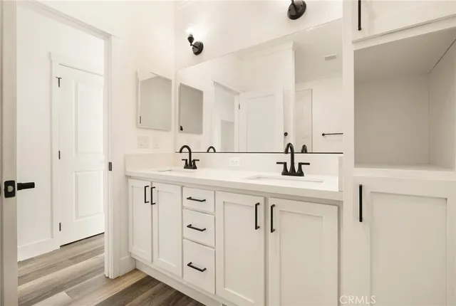 a bathroom with a double vanity sink a mirror and a bathtub
