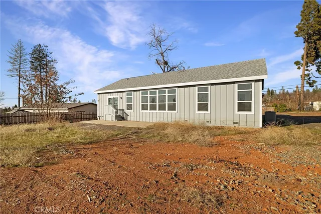 a view of a house with wooden fence and a floor to ceiling window