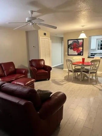 a living room with furniture a fireplace and a chandelier