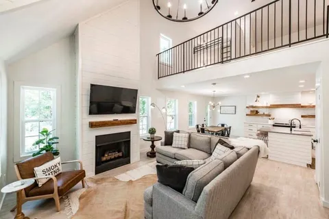 a living room with furniture a fireplace and a flat screen tv